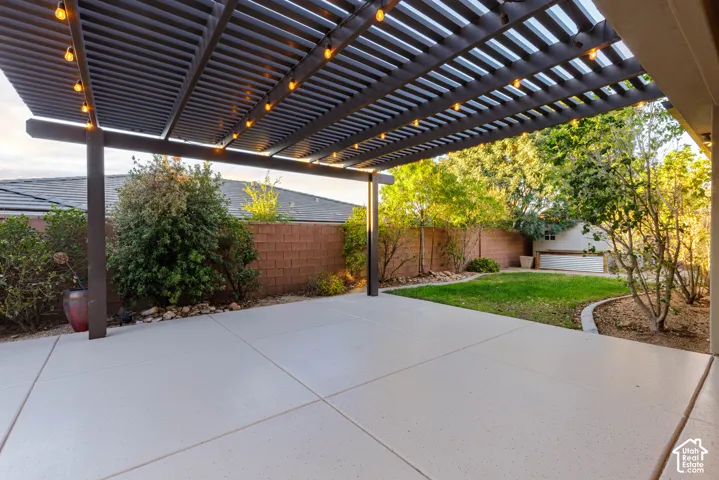Patio: Covered patio under the pergola, with lawn and mature landscaping beyond