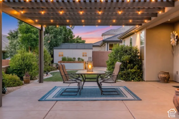 Patio: String lights glow under the pergola at dusk