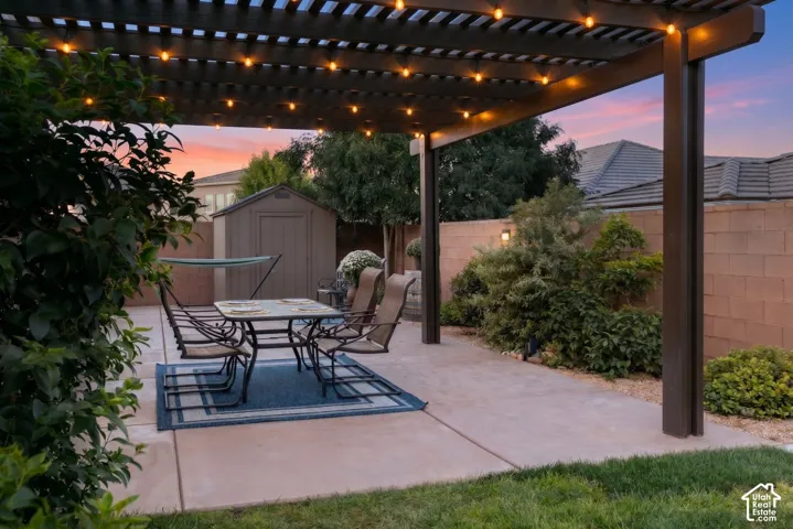 Backyard: Pergola, block wall, and mature landscaping at dusk