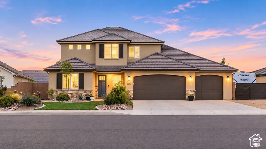 Front Exterior: Twilight over a two-story home with a three-car garage in Steeplechase at Washington