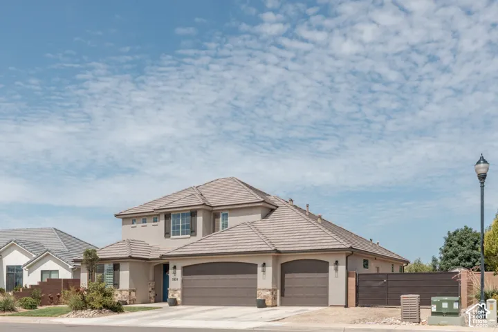 Front Exterior: Stone accents, a three-car garage, and low-water desert landscaping