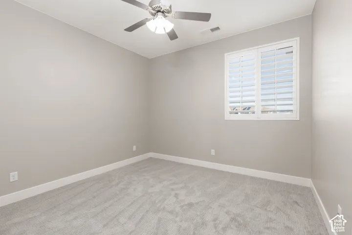 Bedroom: Upstairs bedroom with new carpet, plantation shutters, and a ceiling fan