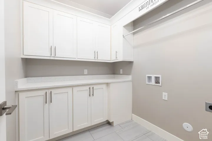 Laundry Room: Upper and lower cabinets, a folding counter, and a hanging rod