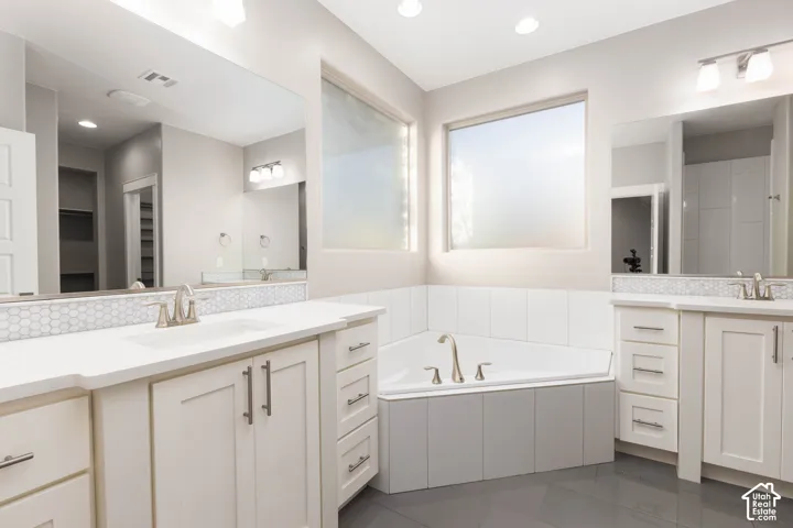Primary Bathroom: Corner soaking tub set between two separate vanities