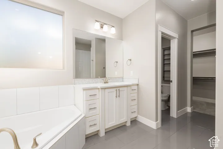 Primary Bathroom: Second vanity, a private toilet room, and the walk-in closet just beyond