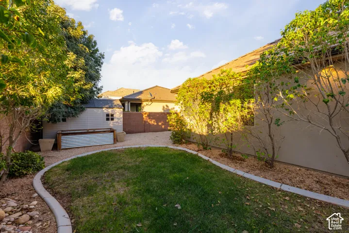 Backyard: Level lawn, mature trees, and a storage shed inside the block wall