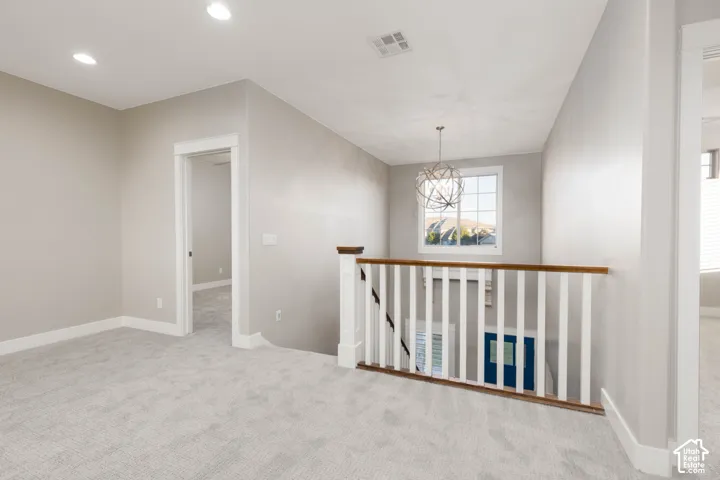 Loft: Wood railing and a statement chandelier at the top of the stairs