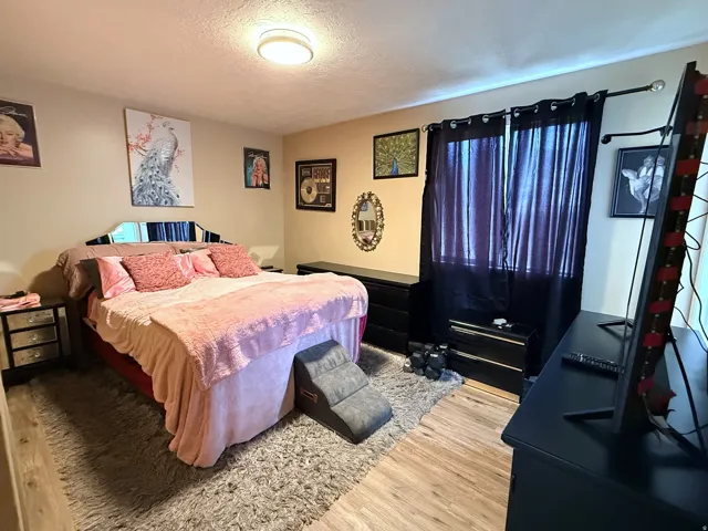 Neutral wall finishes, wood-finish flooring, and a flush-mount ceiling light