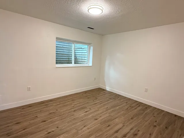Wood-finish flooring, white walls, and a contemporary ceiling light fixture