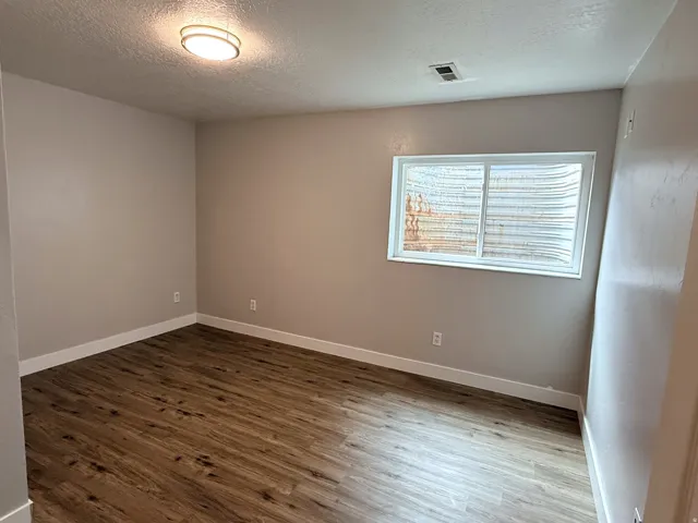 Wood-finish flooring, neutral wall tones, and a flush-mount ceiling light