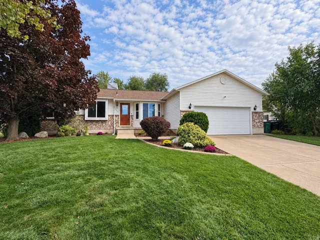 Single-story residence featuring a concrete driveway, attached garage, and a front entry with a wood-finish door