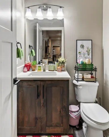 Bathroom featuring a wood-finish vanity with dark hardware, an integrated sink, and a vanity light fixture