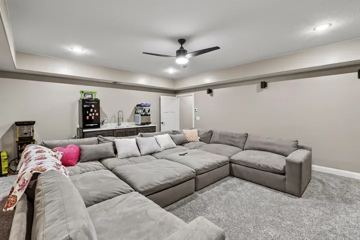 Recessed lighting, ceiling fan, built-in wet bar with sink, built-in mini-fridge, and wall-mounted speakers