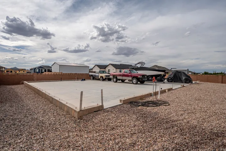 Concrete foundation with gravel landscaping, surrounded by a perimeter block wall