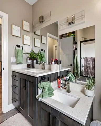 Dual-vanity bathroom featuring white quartz countertops, black cabinetry with multiple drawers, rectangular vessel sinks, and chrome wall-mounted faucets