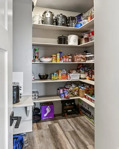 Spacious pantry with five built-in shelves offering abundant storage for dry goods, small appliances, and kitchen essentials