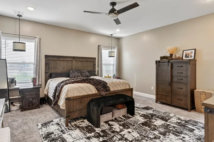 Recessed lighting, ceiling fan, neutral wall tones, two windows with blinds, and carpeted flooring