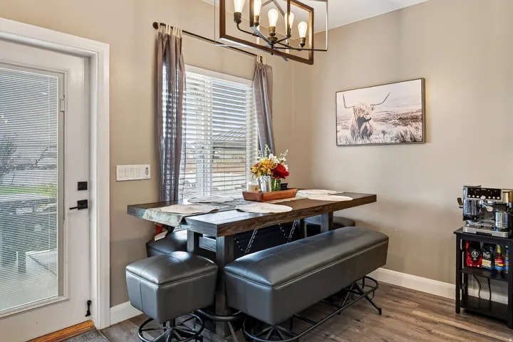 Wood-finish flooring, white trim, and a window with blinds