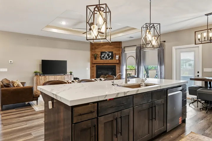 Spacious kitchen island with a white stone countertop, built-in sink, and stainless steel dishwasher