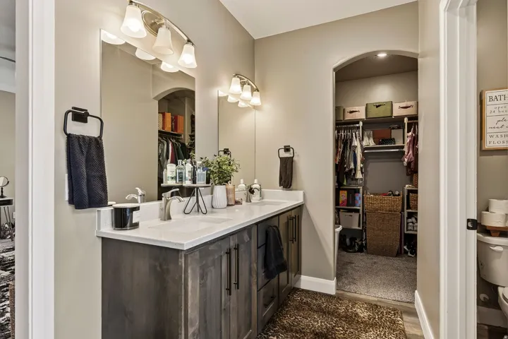 Primary Bathroom with Dark Wood Vanity, Quartz Countertop, and Dual Vessel SinksThis spa-inspired bathroom features a custom dark wood vanity with ample storage, a pristine white quartz countertop, and dual ceramic vessel sinks