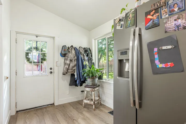 Bright kitchen featuring stainless steel appliances, wood-finish flooring, and abundant natural light from multiple windows