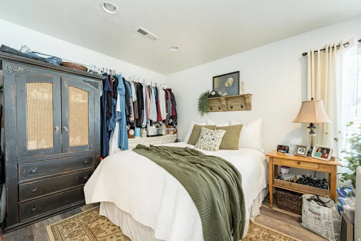 Recessed lighting, wood-finish flooring, and window with light-filtering curtains