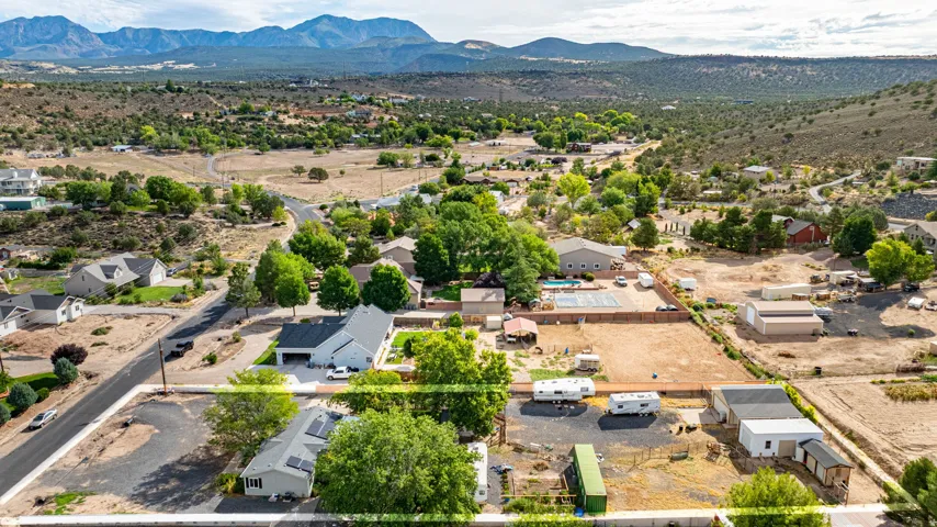 Expansive property with multiple structures, including a residence with a paved driveway and an additional building
