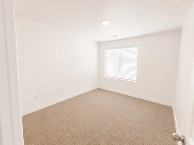 Neutral wall paint with carpet flooring, window with blinds, recessed lighting