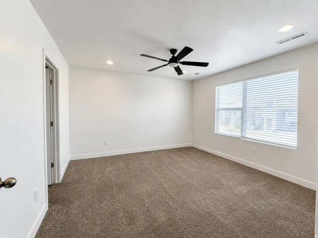 Neutral wall color with recessed lighting, ceiling fan, and window with blinds