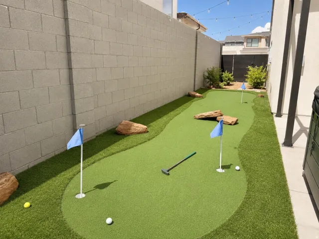 Private putting green with artificial turf, multiple holes, decorative boulders, and perimeter landscaping