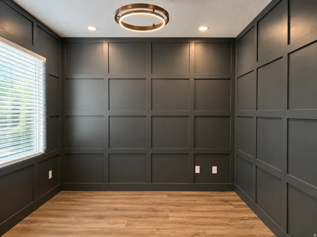 Board and batten accent walls, wood-finish flooring, recessed lighting, and a contemporary circular chandelier