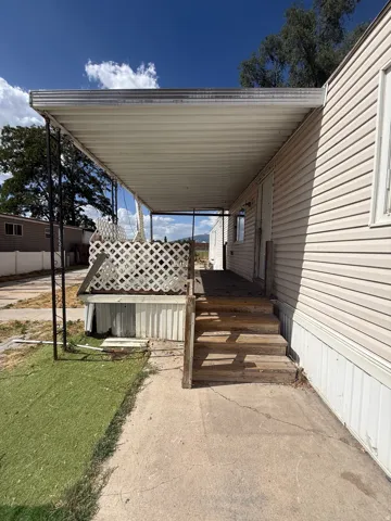 Covered porch entry with wood steps and lattice railing