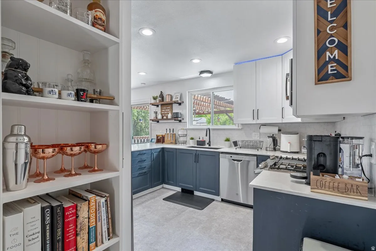 Kitchen featuring two-tone cabinetry, stainless steel appliances, a built-in dishwasher, and a gas range
