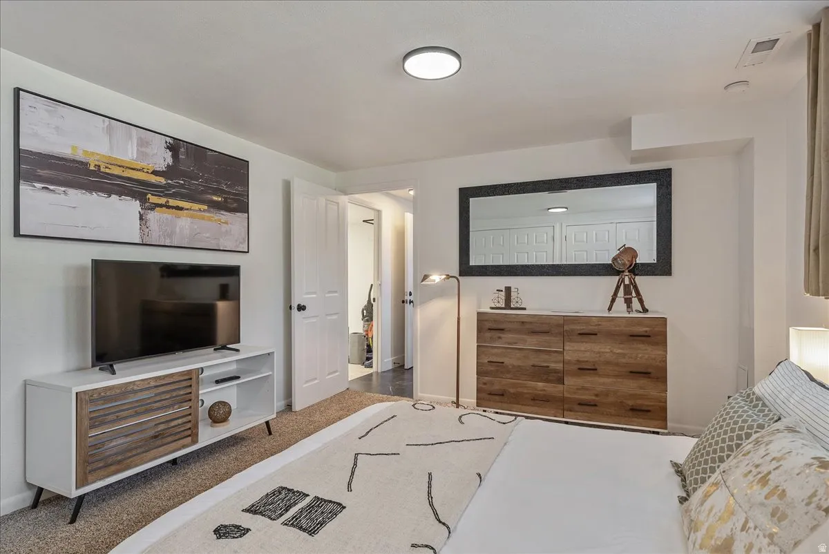 Carpeted flooring, recessed ceiling light, white painted walls, and white trim throughout