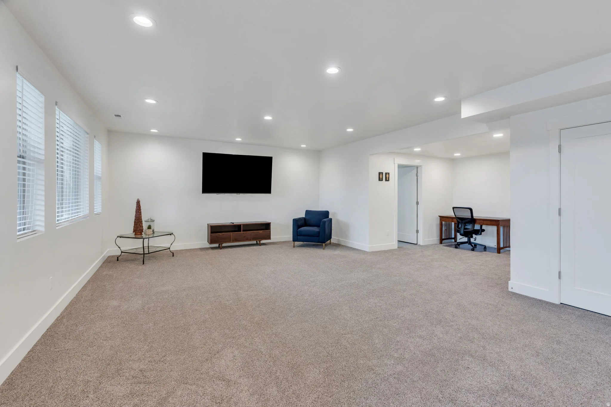 Expansive room with recessed lighting, multiple windows, carpet flooring, and a dedicated alcove