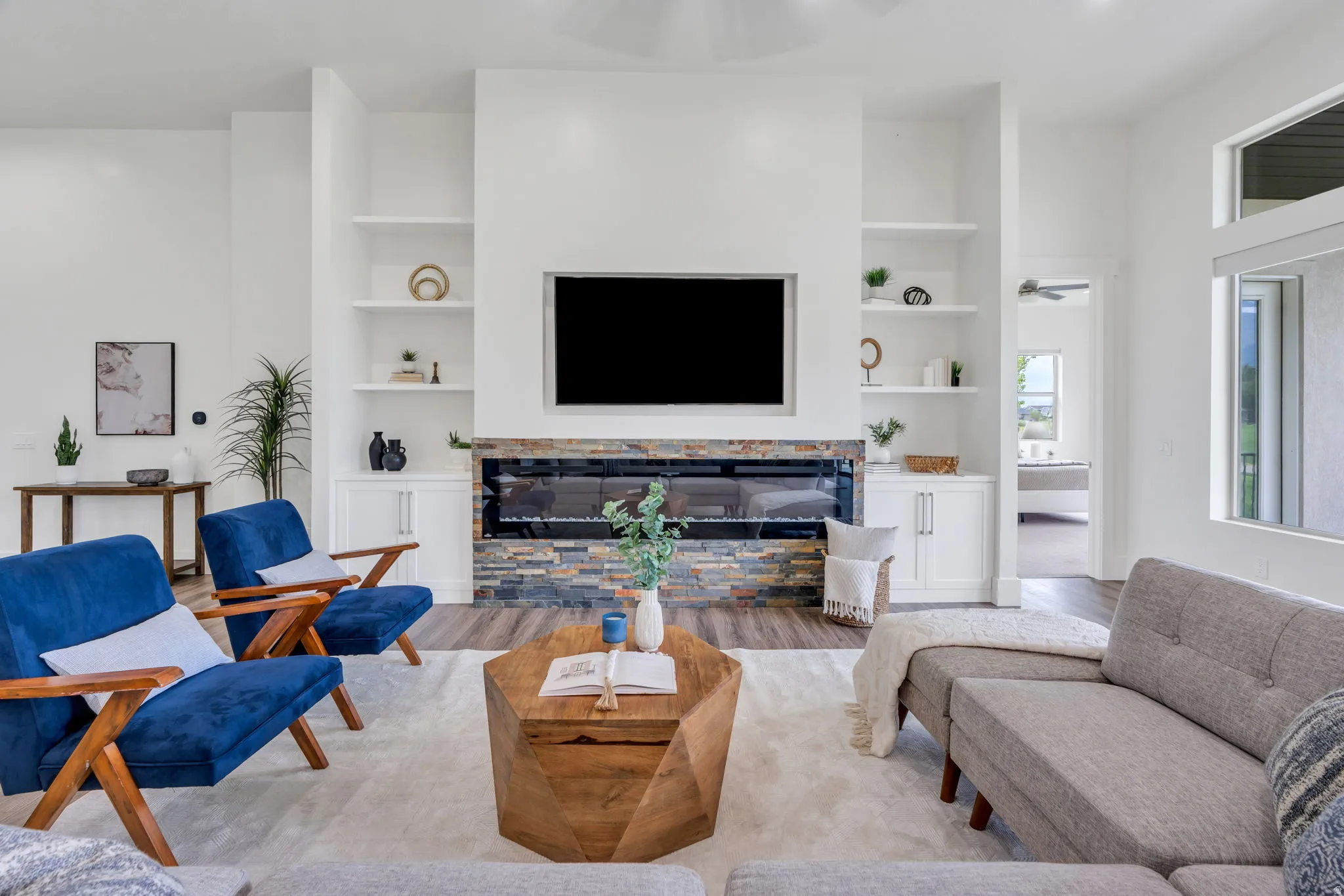 Fireplace featuring a stacked stone surround, built-in shelving, and recessed cabinetry