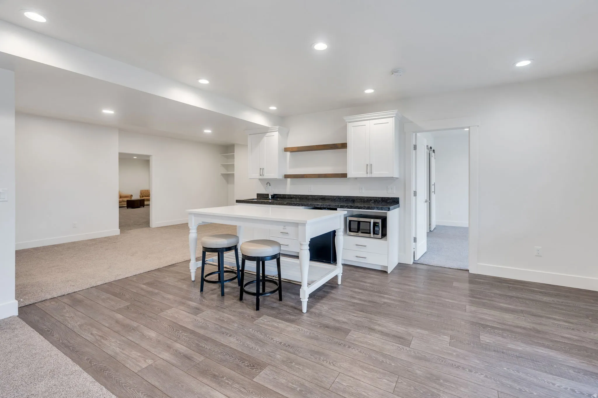 Two-tone flooring with wood-finish planks and carpeted areas