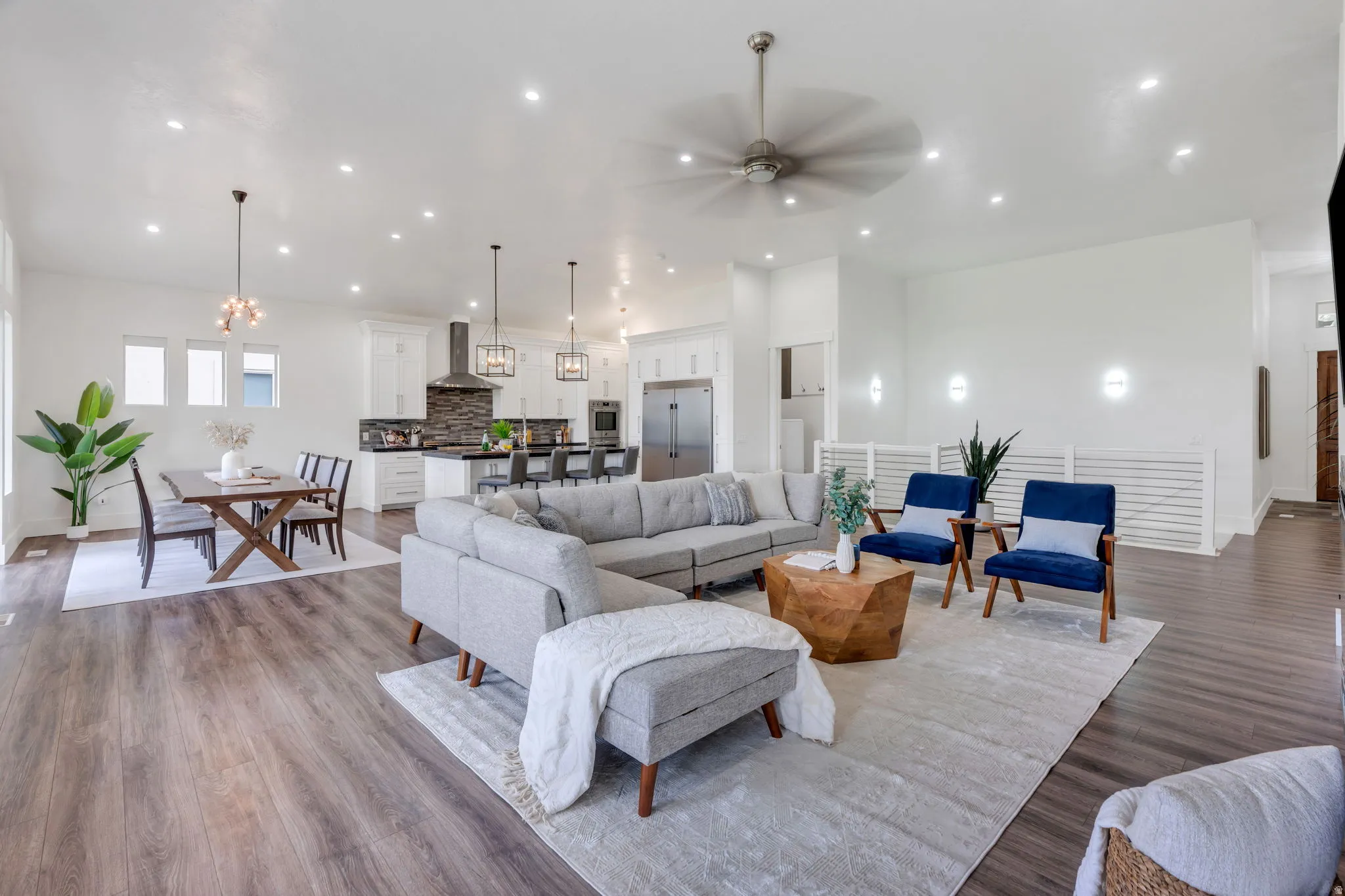 Open-concept living space featuring wood-finish flooring, recessed lighting, and a modern ceiling fan