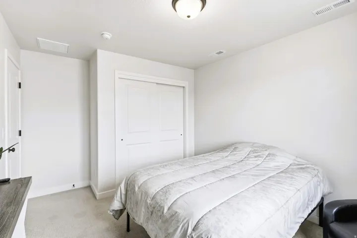 Bedroom #4 Wall-to-wall carpeting, white interior walls, overhead flush-mount light fixture, and a built-in closet with sliding doors.