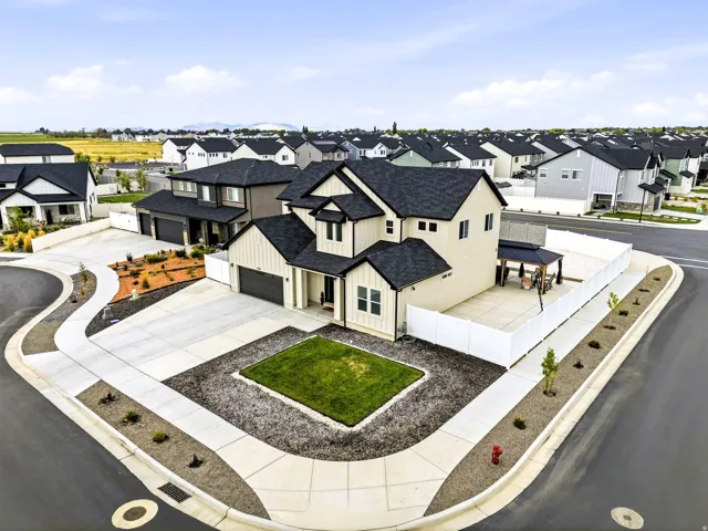 Contemporary two-story residence featuring a two-car garage, established front landscaping, and a covered back patio with a gazebo