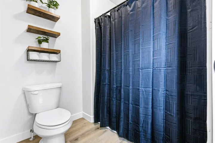 White toilet with a matching lid bath/shower combo.