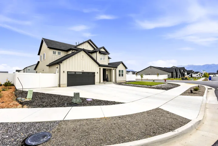 Contemporary architecture featuring board and batten siding, dark shingle roofing, an attached garage, and a concrete driveway