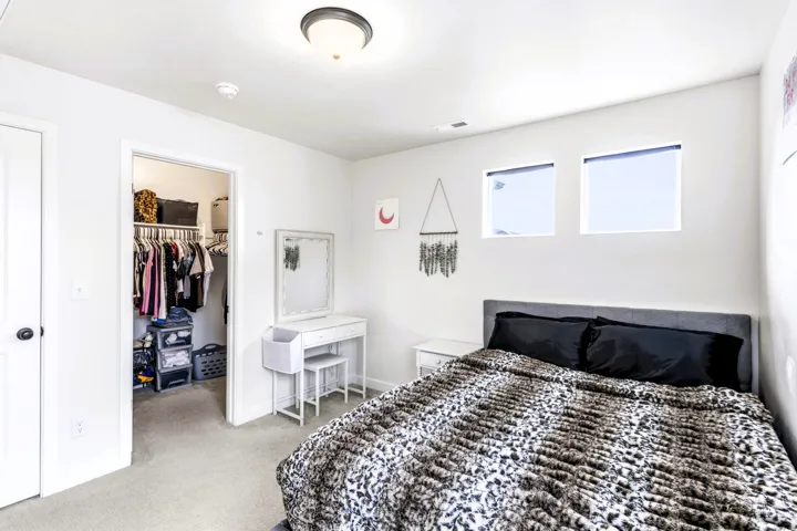 Bedroom #2 with flushed mount lighting, light gray carpet flooring, white walls, and a oversized built-in closet with shelving