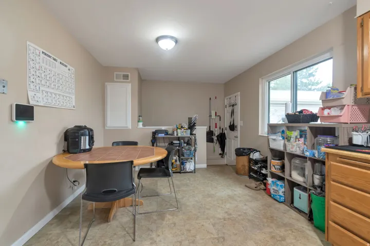 Recessed ceiling lighting, tiled flooring, natural wood cabinetry, and a large window