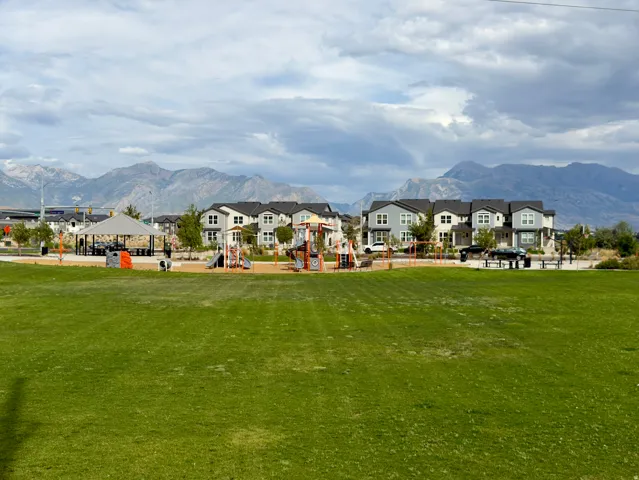 Expansive green space and playgrounds with mountain backdrop