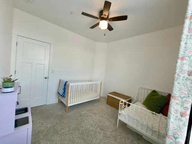 Large bedroom with ceiling fan & large window