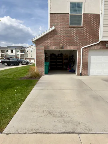 One car garage door open, lots of storage inside and long driveway for additional parking