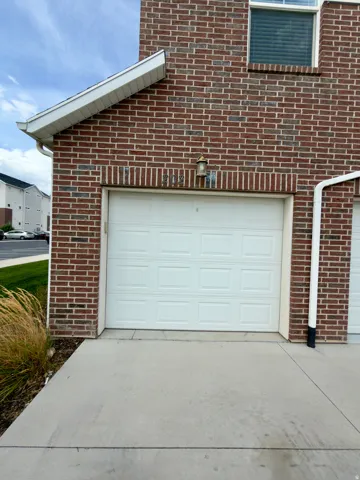Brick exterior with a white panel garage door