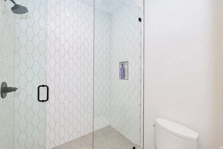 Walk-in shower with clear glass enclosure and black hardware