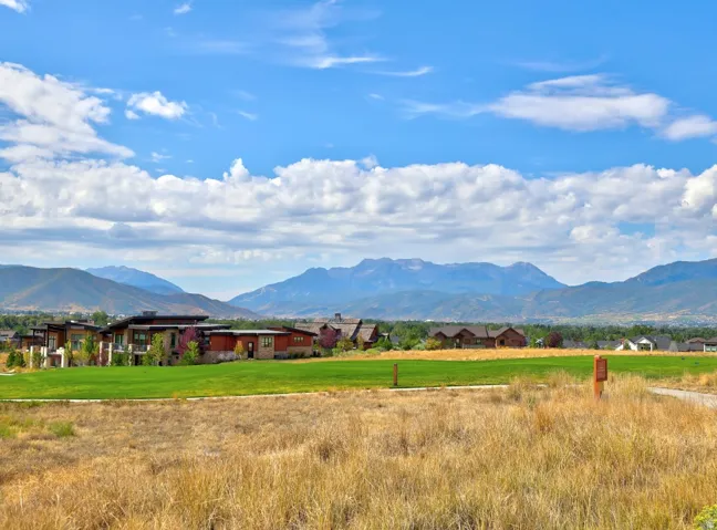 Contemporary architectural styles, expansive green space, and distant mountain backdrops